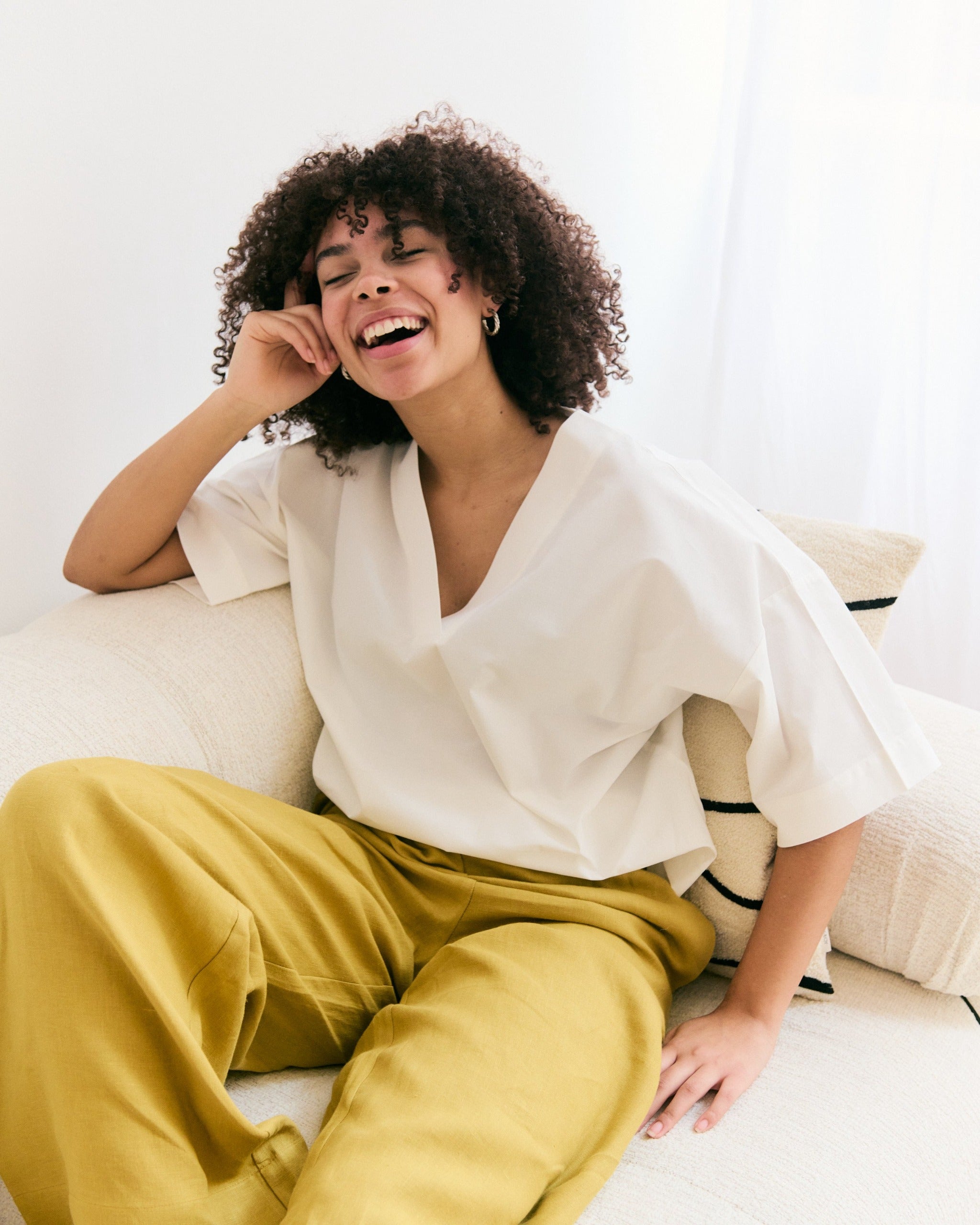 Woman in white oversized mana loa blouse made of 100% organic cotton.