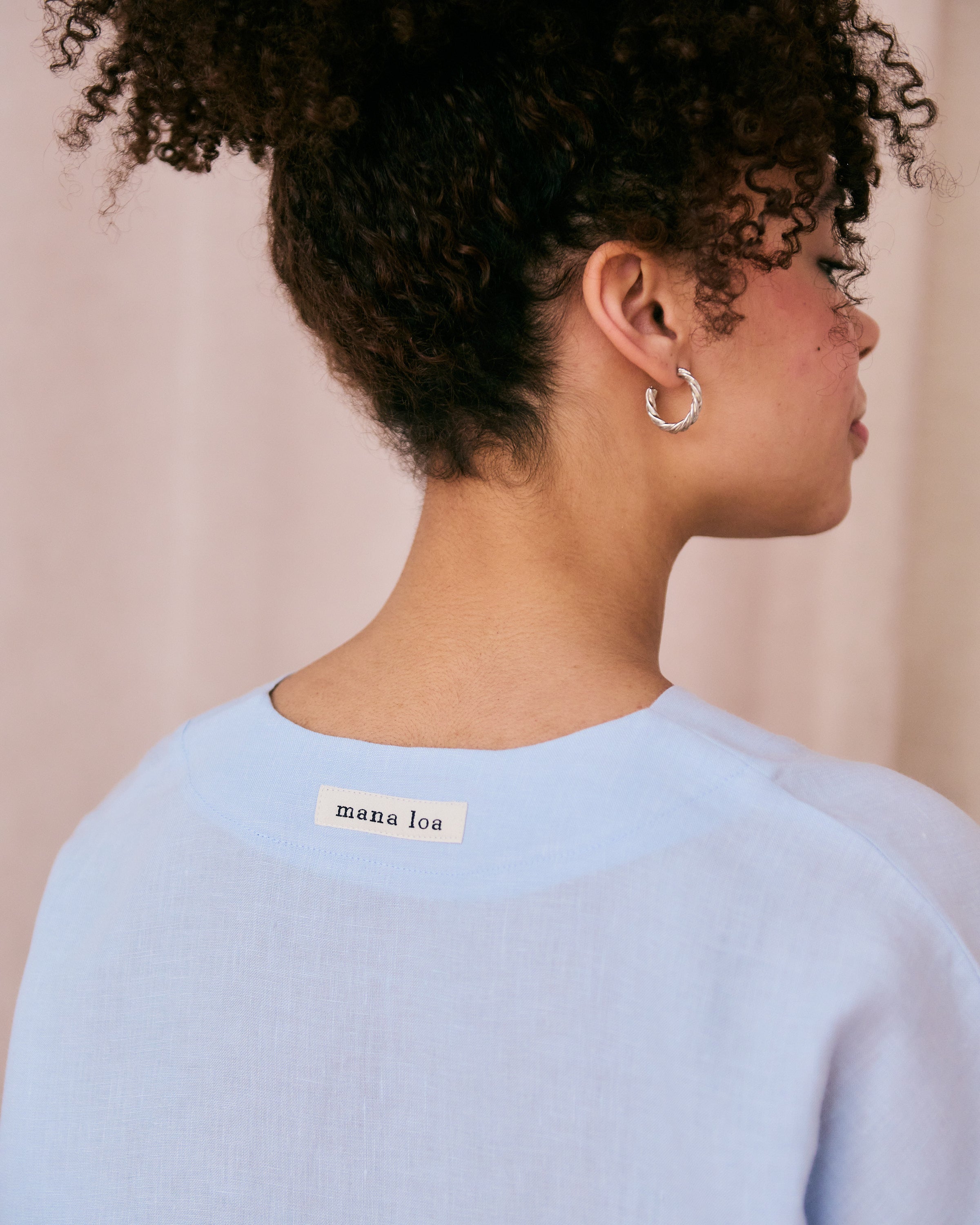 Back of a light blue linen top with mana loa label.