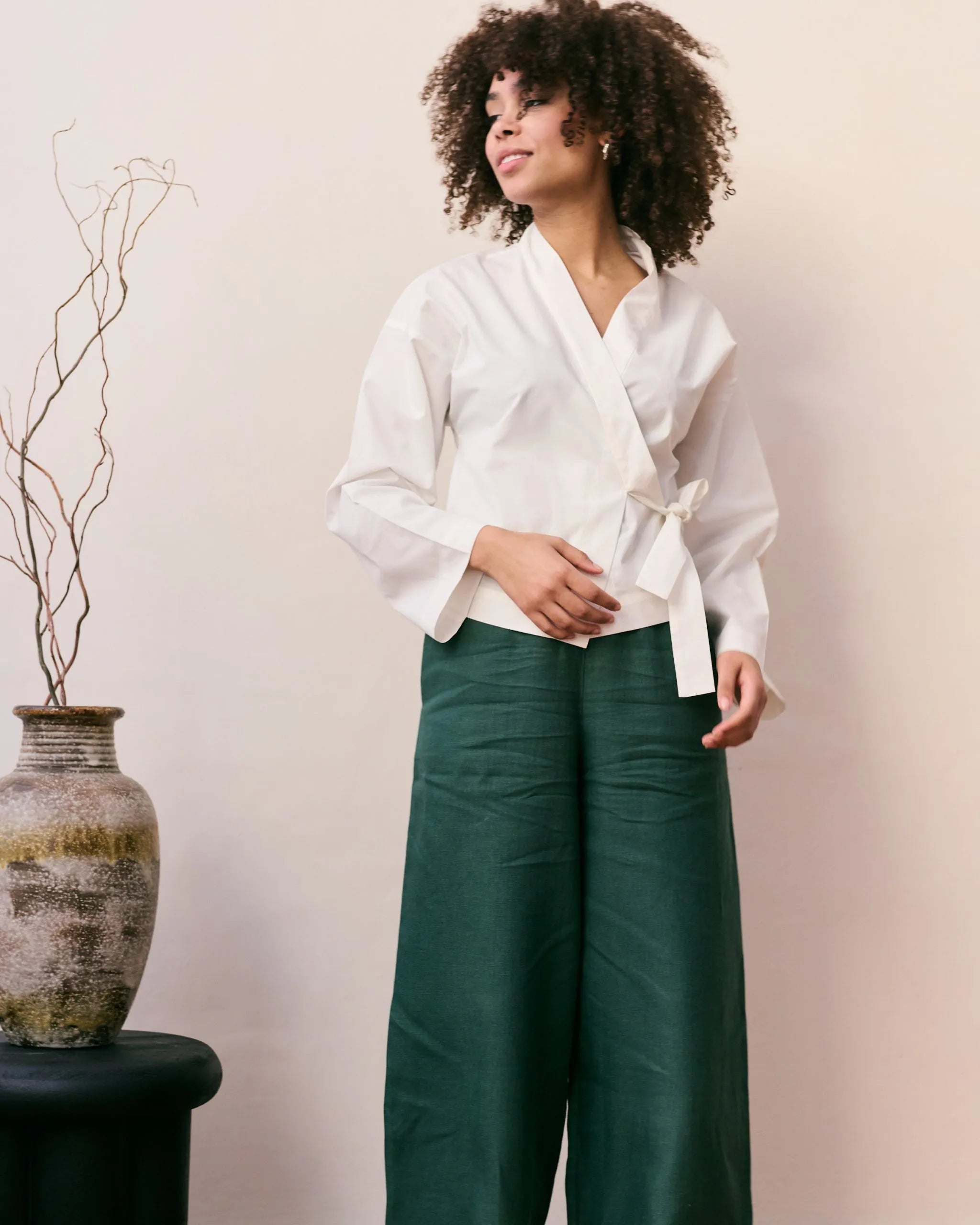 Off-white wrap blouse in 100% organic cotton and a green linen pants.